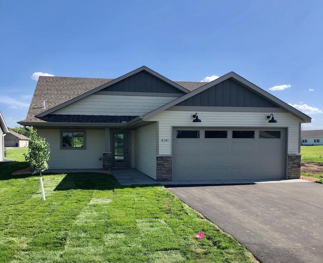 view of front of home featuring aphalt driveway, a garage, roof with shingles, a front lawn, and board and batten siding