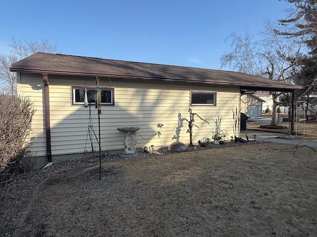 view of home's exterior with a carport and a yard