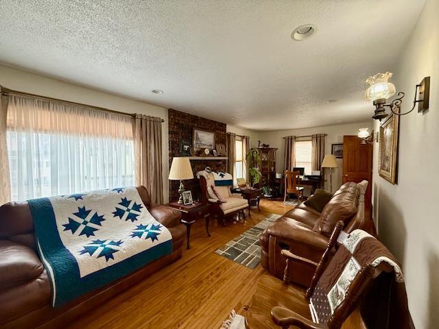 living room featuring a textured ceiling, a chandelier, and wood finished floors