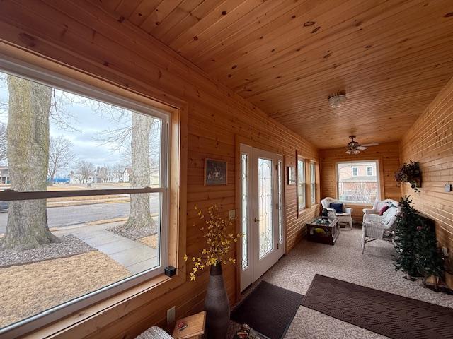 sunroom featuring a ceiling fan, lofted ceiling, and wooden ceiling