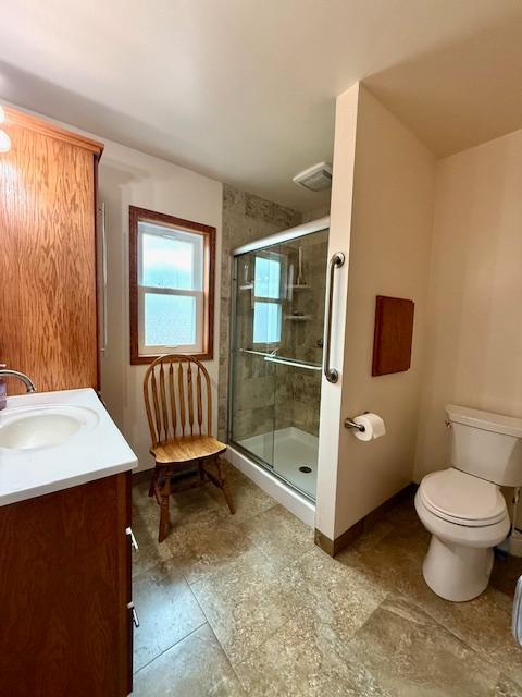 full bath featuring visible vents, baseboards, toilet, vanity, and a shower stall