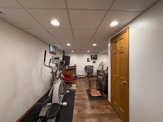 workout room with recessed lighting, dark wood-style flooring, and a paneled ceiling