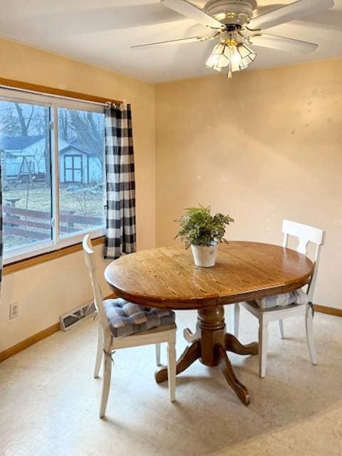 unfurnished dining area featuring visible vents, a healthy amount of sunlight, baseboards, and a ceiling fan