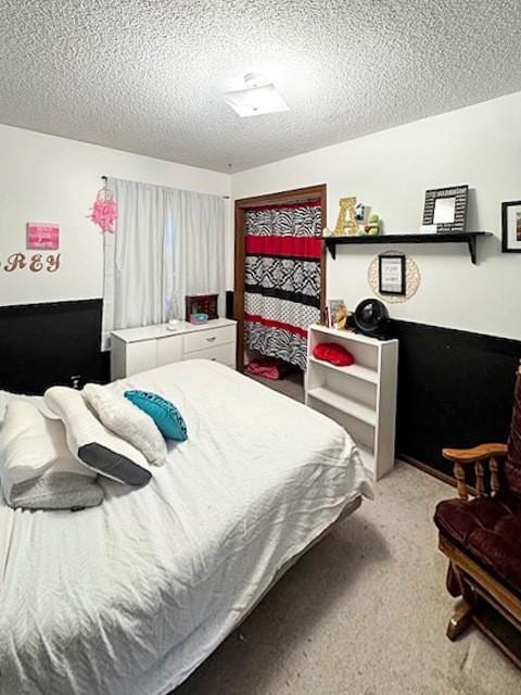 bedroom featuring light carpet and a textured ceiling