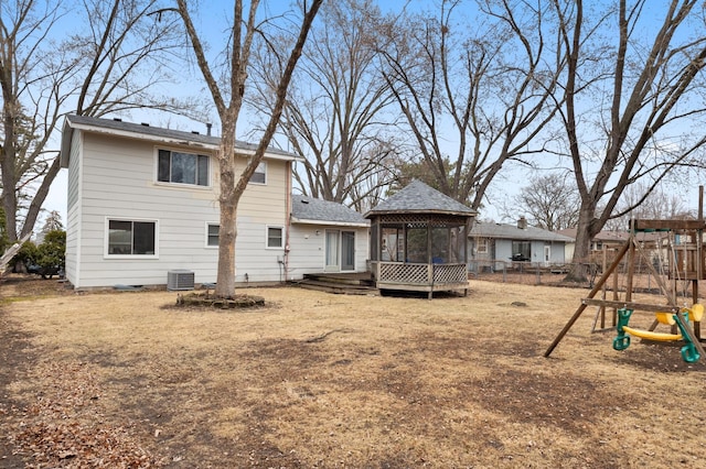 back of house featuring fence, central AC, a gazebo, a deck, and a playground