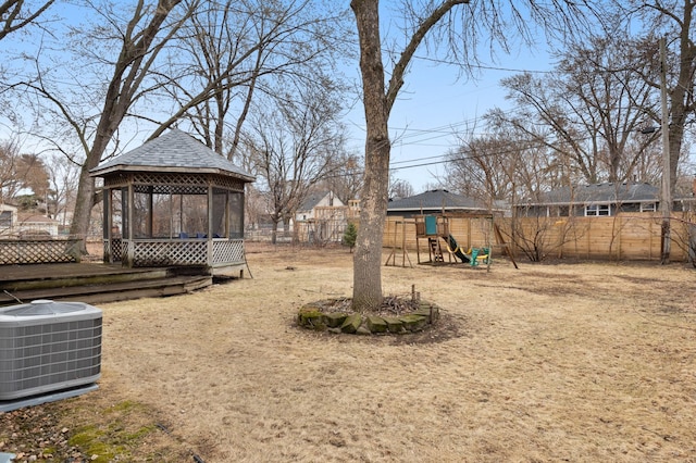 view of yard with a gazebo, cooling unit, a fenced backyard, and a playground