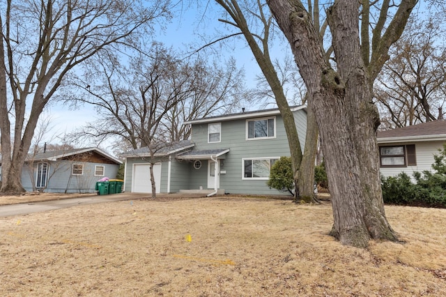 traditional-style house featuring an attached garage and concrete driveway