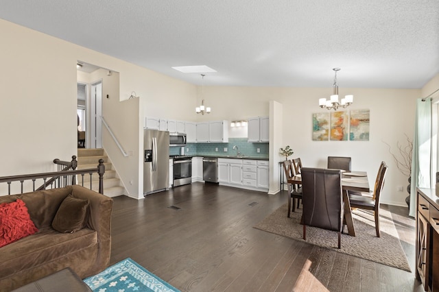 dining space featuring dark wood finished floors, vaulted ceiling, a notable chandelier, and stairway