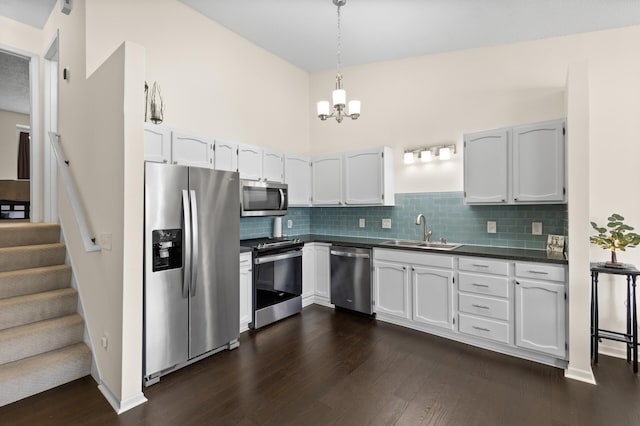 kitchen featuring dark countertops, dark wood-type flooring, stainless steel appliances, and a sink