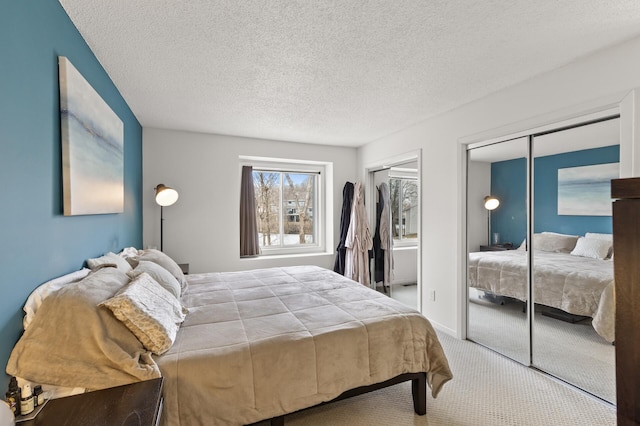 bedroom featuring multiple closets, baseboards, carpet floors, and a textured ceiling