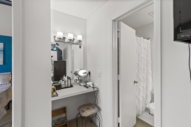 ensuite bathroom with connected bathroom and a textured ceiling