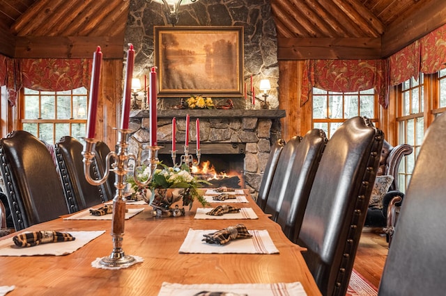 dining room featuring wooden ceiling and a stone fireplace