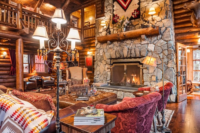 living area with log walls, hardwood / wood-style flooring, a high ceiling, beamed ceiling, and a chandelier
