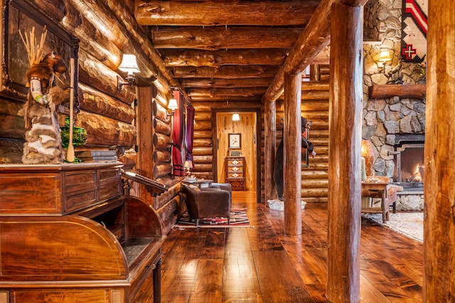 sitting room with log walls and hardwood / wood-style floors