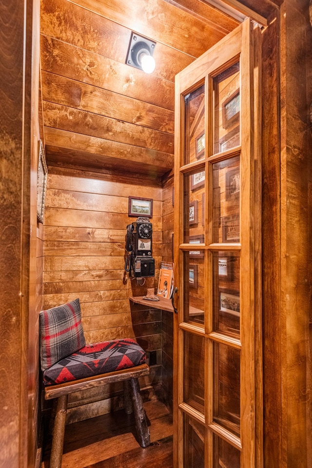 sitting room featuring wooden walls and wood finished floors