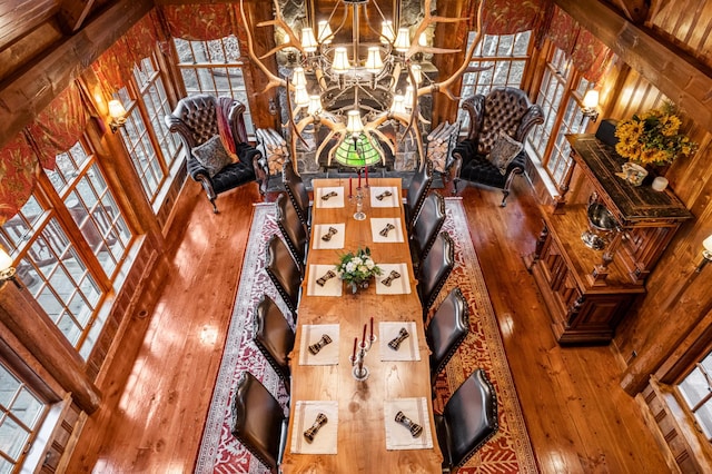 unfurnished living room featuring hardwood / wood-style flooring, healthy amount of natural light, a chandelier, and a towering ceiling