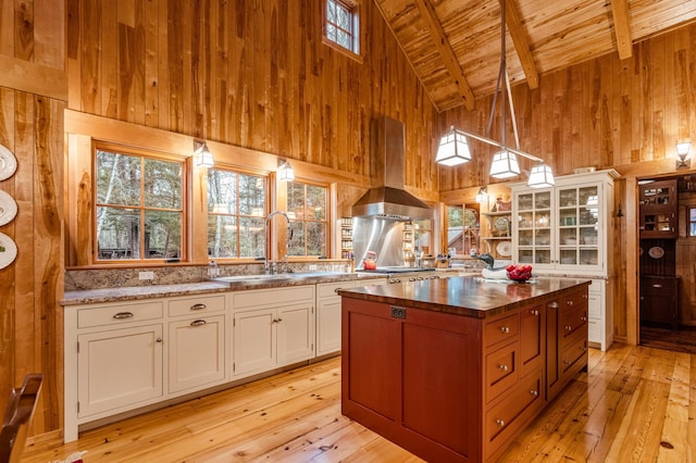 kitchen with extractor fan, wooden ceiling, wooden walls, high vaulted ceiling, and butcher block counters