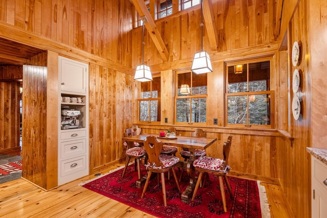 dining space with wood walls and light wood-type flooring