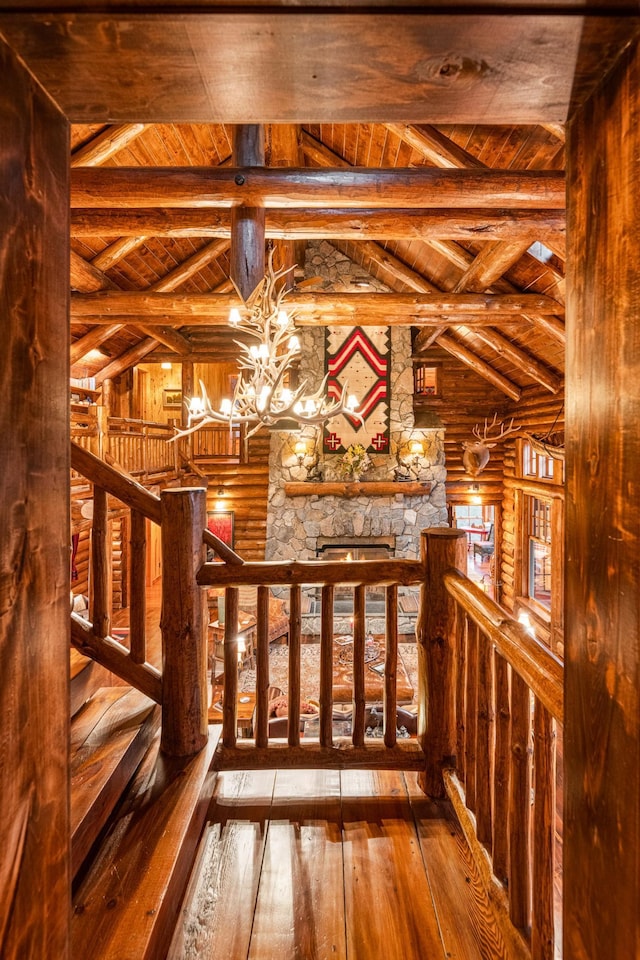 stairway featuring rustic walls, wooden ceiling, a chandelier, and hardwood / wood-style flooring