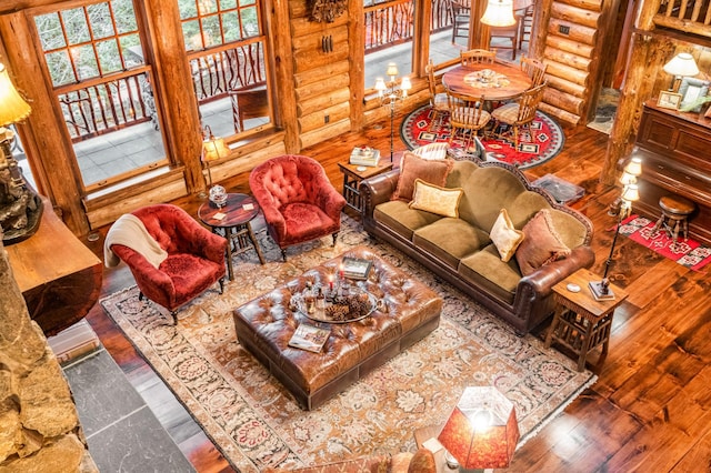 living area with log walls and hardwood / wood-style flooring