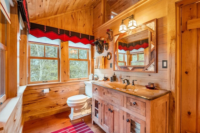 bathroom with wood walls, wood ceiling, plenty of natural light, wood finished floors, and toilet