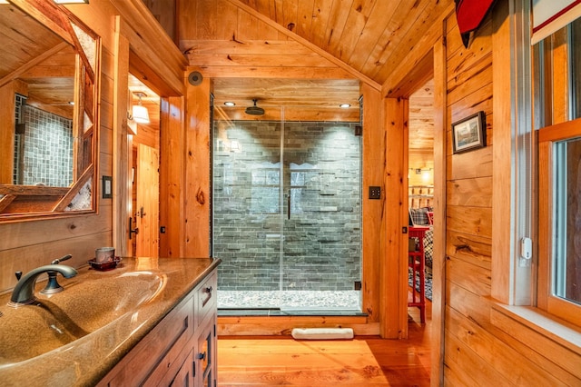 full bathroom with wood walls, a stall shower, wooden ceiling, vanity, and lofted ceiling