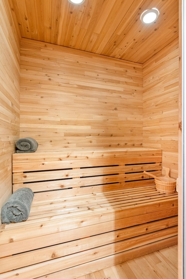 relaxing sauna / steam room featuring wooden ceiling and wooden walls