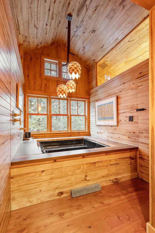 kitchen with wood ceiling, wood walls, lofted ceiling, hardwood / wood-style floors, and hanging light fixtures