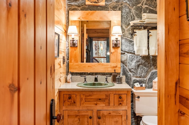 half bath featuring toilet, vanity, and backsplash