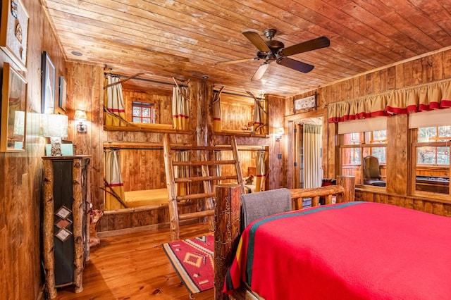 bedroom featuring wood ceiling, wood walls, and wood-type flooring