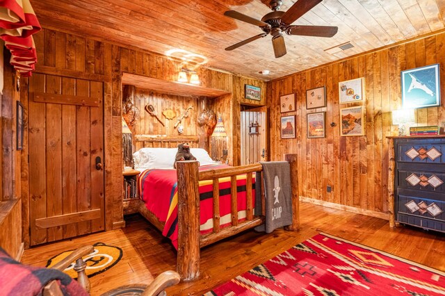 bedroom with wooden ceiling, wooden walls, and wood-type flooring