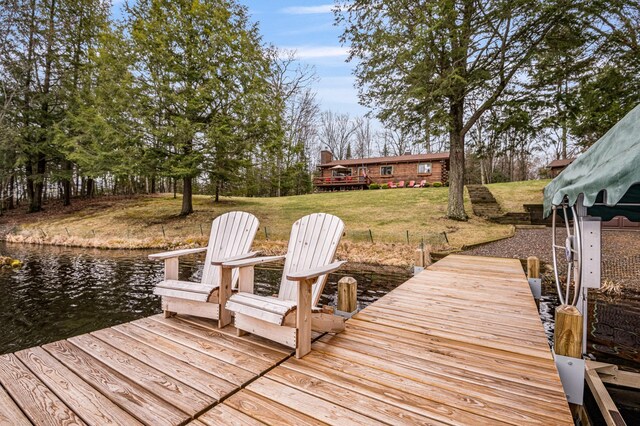 dock area with a water view and a lawn
