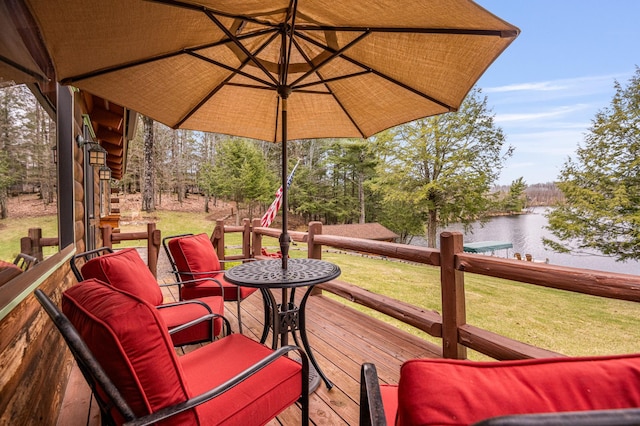 wooden terrace with a water view and a lawn