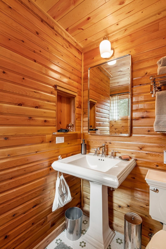half bath with toilet and wood walls
