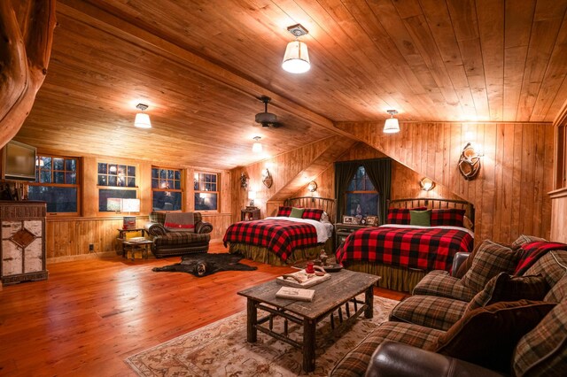 bedroom with wood walls, wood ceiling, wood finished floors, and lofted ceiling
