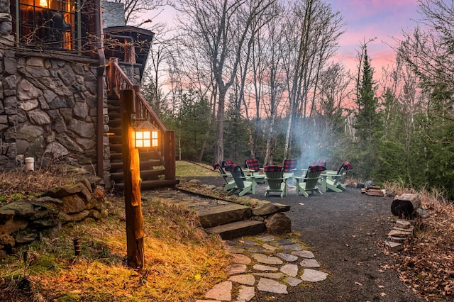 yard at dusk with stairs and an outdoor fire pit