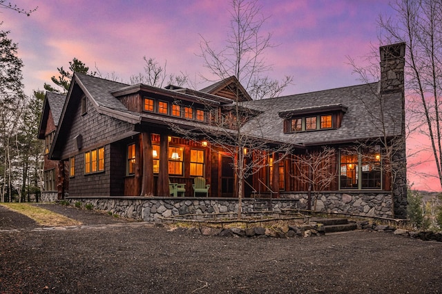 view of front of property featuring a chimney and a porch