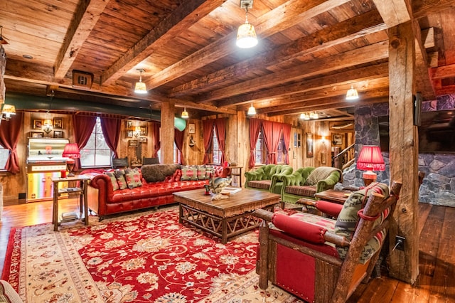 living area with a wooden ceiling with exposed beams, hardwood / wood-style floors, and wood walls