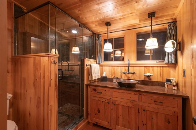 full bathroom featuring vanity, a stall shower, wood walls, and wooden ceiling