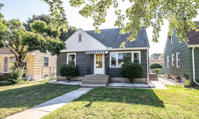 view of front of house featuring a front lawn and roof with shingles