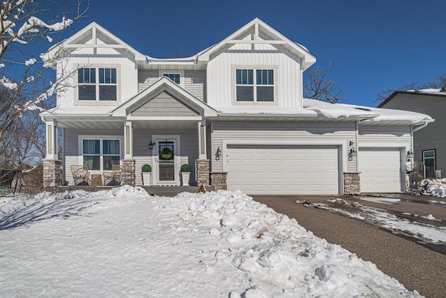 view of front of home featuring covered porch, stone siding, and board and batten siding