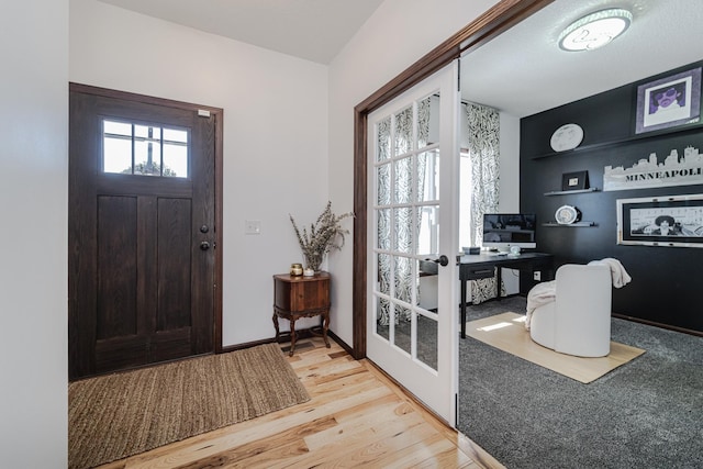 entrance foyer with light wood-style floors, french doors, and baseboards