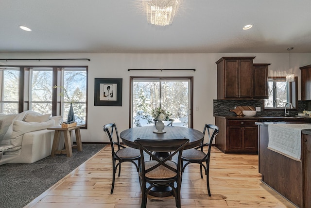 dining room featuring light wood finished floors, an inviting chandelier, and recessed lighting