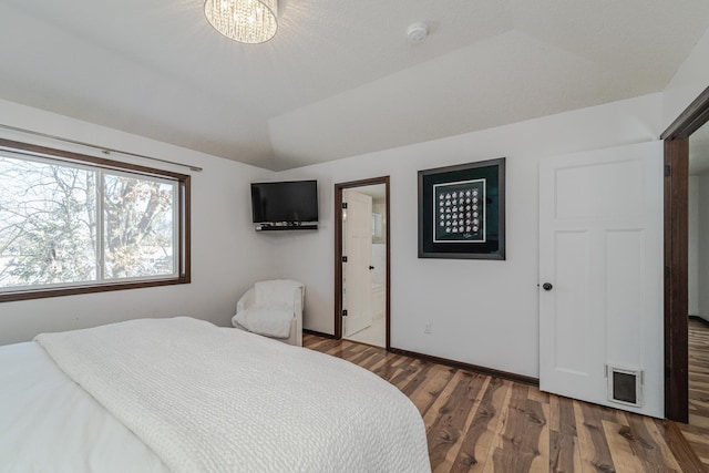 bedroom featuring visible vents, vaulted ceiling, baseboards, and wood finished floors