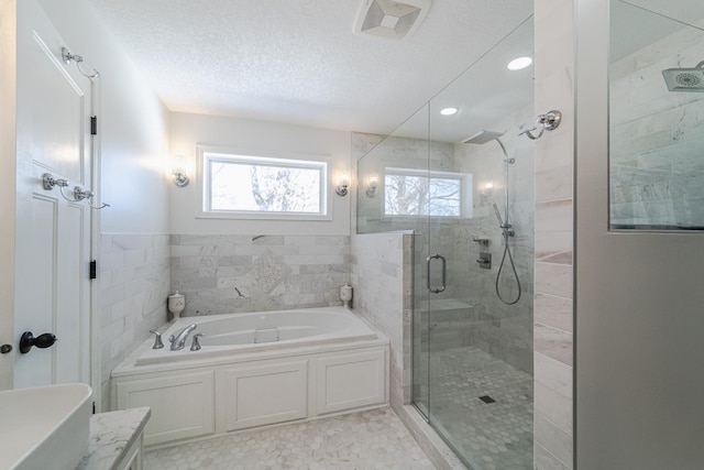 bathroom featuring a garden tub, a shower stall, visible vents, and a textured ceiling