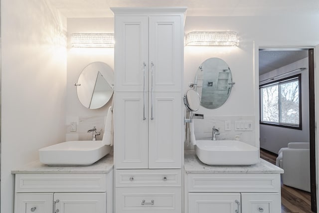 full bath with wood finished floors, a sink, and double vanity