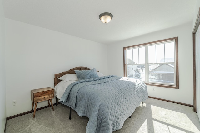 bedroom featuring baseboards and light colored carpet