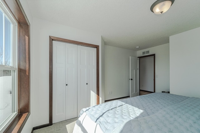 bedroom with a closet, visible vents, and a textured ceiling