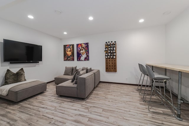 living room with baseboards, wood finished floors, and recessed lighting