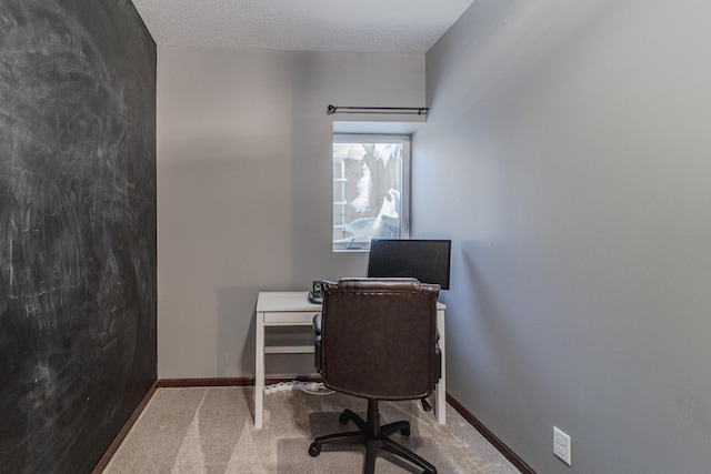 office area with a textured ceiling, carpet floors, and baseboards